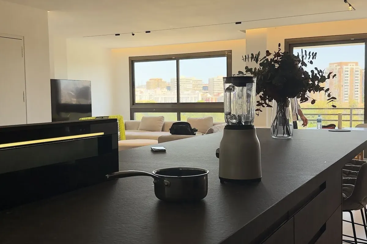 Isla de cocina oscura con extracción integrada en un espacio de diseño